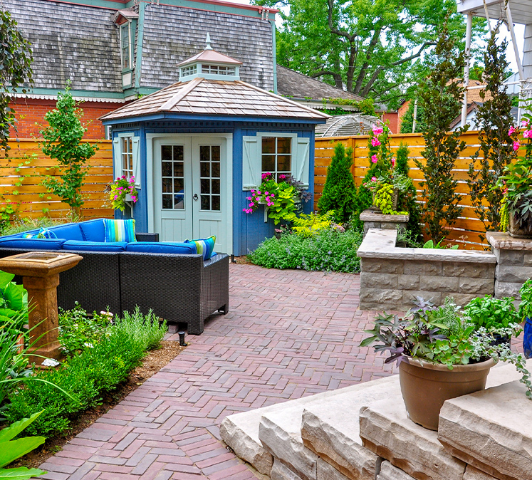 a close up of a flower garden in front of a brick building